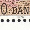 2 små pletter, vandret kolon, under D i DANMARK og ud for 1 i 1976